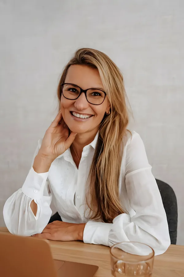 Anouk van Dongen, lachend aan haar bureau