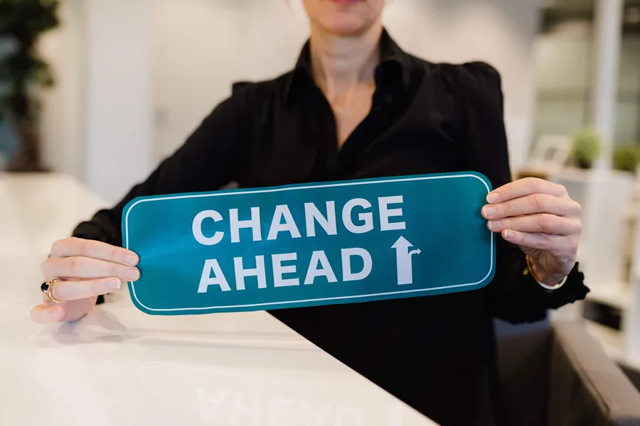Anouk houdt een groen bordje vast: Change ahead